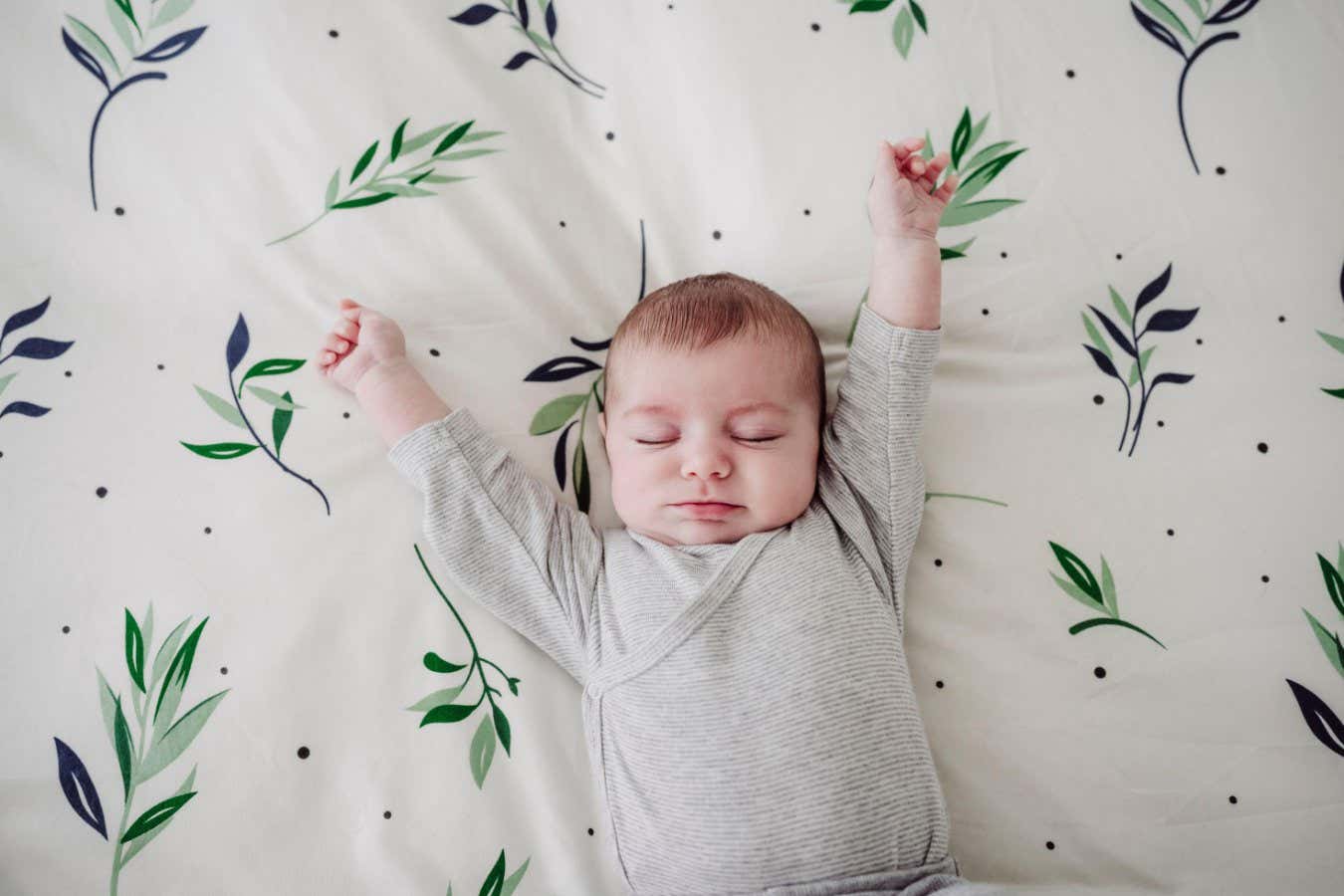 2WM0P5Y Cute baby girl stretching arms lying in bed at home